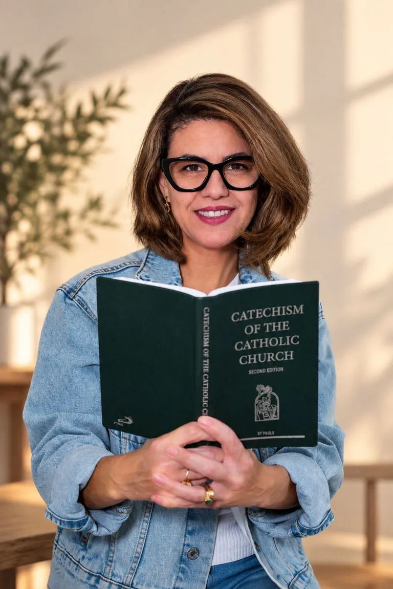 Carol de óculos, sorrindo, com o Catecismo da Igreja Católica nas mãos